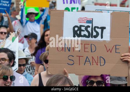 Atlanta, GA/USA - 5. April 2025: Frau hält ein Schild mit der Aufschrift „Resistst – United We Stand“ auf dem Hands Off march am 5. April 2025 in Atlanta, GA. Stockfoto