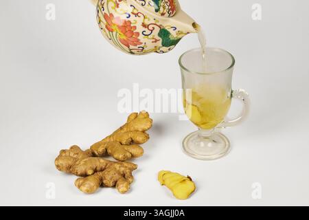 Ingwerwurzel-Infusion, serviert in einer Teetasse, um die Kälte als natürliches Antibiotikum zu bekämpfen Stockfoto