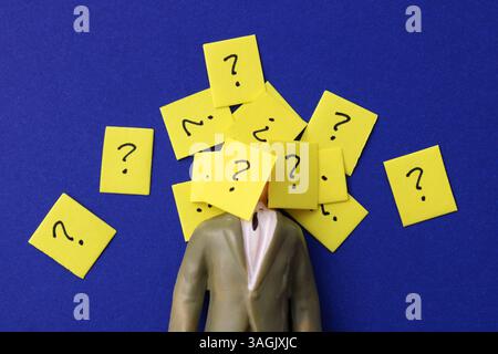 Geschäftsmann mit vielen Fragezeichen im Gesicht Stockfoto