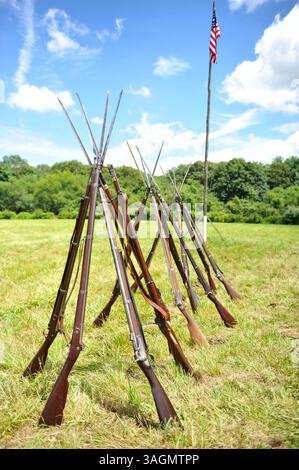 21. Juli 2012 - Old Bethpage, New York, USA - Stapel von Musketen aus dem Bürgerkrieg mit Bajonetten, mit amerikanischer Flagge auf der Rückseite, bei der Wiedererrichtung von Camp Scott, einem Ausbildungslager der Union Army, Old Bethpage Village Restoration, zum Gedenken an das 150. Jahrestag des Amerikanischen Bürgerkriegs (Credit Image: © Ann E Parry/ZUMAPRESS.com) Stockfoto