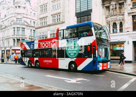London Open Top TOOTBus für Touristen, die einen Open Air Bus besuchen UK Flag Lackierung auf London Street, emissionsarme öffentliche Verkehrsmittel Stockfoto