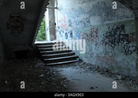 Baufällige Treppe in einem alten Haus mit Ziegel- und Gipssplittern. Stockfoto