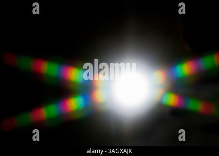 Beugung. Abstraktes Muster, das durch gebeugtes Licht gebildet wird. Ein Sternenstrahl aus weißem Licht, das in das sichtbare Farbspektrum verteilt ist. Weißes Licht kann reaktiviert werden Stockfoto