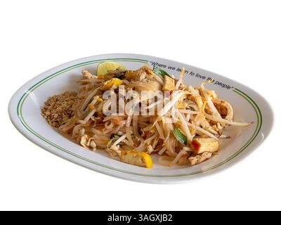 Ein Teller mit köstlichem Pad Thai mit Hühnchen, Tofu, Sojasprossen und Erdnüssen, garniert mit einem Limettenkeil. Stockfoto