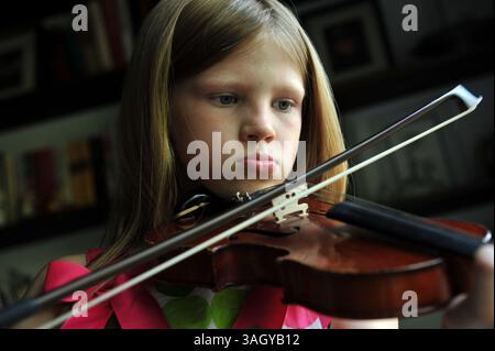 Juli 2009 – Indianapolis, Indiana, USA – während Musikprogramme in öffentlichen Schulen im ganzen Land abgeschnitten oder abgeschnitten werden. Privatlehrer bestehen darauf, dass entschlossene Schüler einen Weg finden sollten, Musikinstrumente zu lernen. IM BILD: 16. Juni 2008 – Indianapolis, Indiana, USA – die achtjährige ALYSSA IM WINTER übt täglich zu Hause ihre Geige und nimmt Privatunterricht bei einem Verwandten, wenn sie kann. (Foto: © Robin Nelson/ZUMA Press) Stockfoto