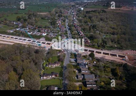 Burton Green, Warwickshire, 9. April 2025: Das kleine Dorf Burton Green wird durch eine riesige HS2-Baustelle geteilt, da sie den Burton Green Tunnel installieren. Die Hochgeschwindigkeitsbahn hat die Strecke einer alten stillgelegten Eisenbahnstrecke genommen, die in den 1970er Jahren in einen Fußweg umgewandelt wurde Das Dorf in der Nähe von Kenilworth hat zwei Häuser abgerissen, um Platz für das erweiterte Baugebiet zu schaffen. Die Straße wird nach Abschluss der Bauarbeiten wieder auf ihren ursprünglichen geraden Weg zurückgeführt. Quelle: British News und Media/Alamy Live News Stockfoto