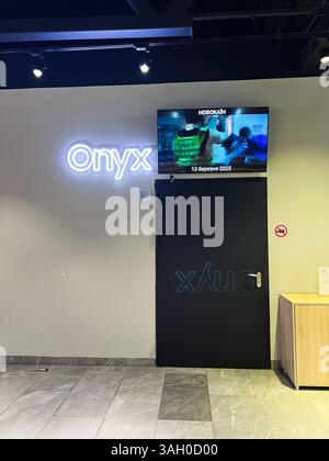 Kiew, Ukraine - 08. April 2025: Gewerbefläche mit minimalistischem Design mit Neonschildern Onyx und eingebautem Fernsehbildschirm. Stockfoto