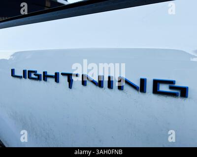 Kiew, Ukraine - 08. April 2025: Detaillierte Ansicht des Emblems eines Fahrzeugs mit dem Wort Ford F-150 Lightning in fettgedruckter Schrift Stockfoto