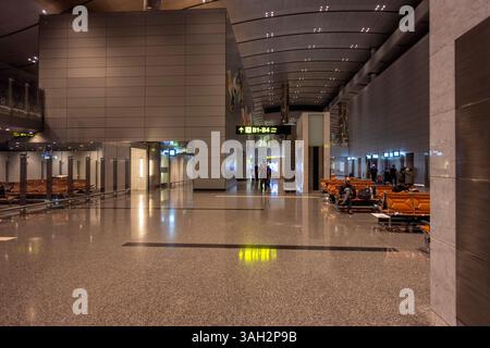 Ein fesselnder Blick bei Nacht auf den internationalen Flughafen Hamad mit seiner modernen Architektur, beleuchtet mit lebendigem Licht Stockfoto