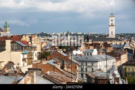 LEMBERG, UKRAINE - 20. Juni 2021: Die Dächer und historischen Gebäude von Lemberg zeigen einzigartige architektonische Stile. Der Charme der Stadt zeigt sich in der Mischung aus alten und neuen Gebäuden unter einem bewölkten Himmel. Stockfoto