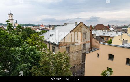 LEMBERG, UKRAINE - 20. Juni 2021: Ein Blick auf die historische Architektur in Lemberg mit alten Gebäuden und Dächern. Üppiges Grün steht im Kontrast zur urbanen Landschaft und fängt das Wesen der Stadt ein. Stockfoto