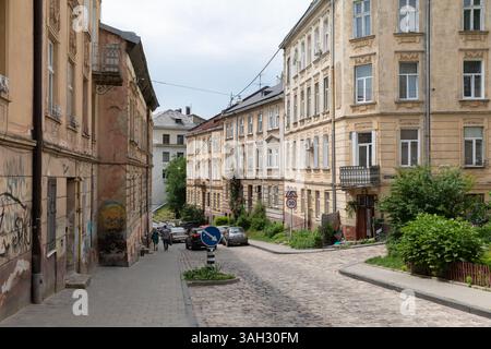 LEMBERG, UKRAINE - 20. Juni 2021: Kopfsteinpflasterstraßen schlängeln sich durch den historischen Teil von Lemberg. Die Gebäude zeichnen sich durch eine komplizierte Architektur aus, und das Grün sorgt für Charme. Stockfoto