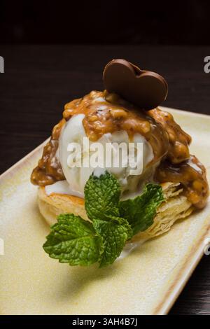 Dessert mit Blätterteig und Eis mit Karamell auf einem Teller Stockfoto