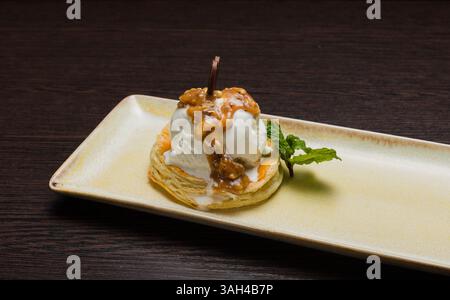 Dessert mit Blätterteig und Eis mit Karamell auf einem Teller Stockfoto