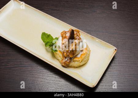 Dessert mit Blätterteig und Eis mit Karamell auf einem Teller Stockfoto
