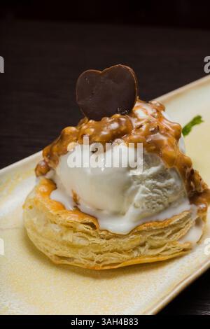 Dessert mit Blätterteig und Eis mit Karamell auf einem Teller Stockfoto
