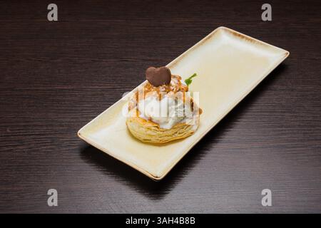Dessert mit Blätterteig und Eis mit Karamell auf einem Teller Stockfoto