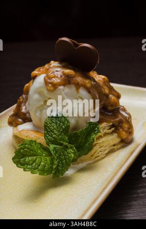 Dessert mit Blätterteig und Eis mit Karamell auf einem Teller Stockfoto