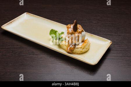 Dessert mit Blätterteig und Eis mit Karamell auf einem Teller Stockfoto