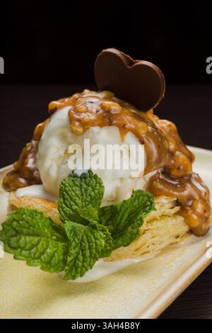 Dessert mit Blätterteig und Eis mit Karamell auf einem Teller Stockfoto