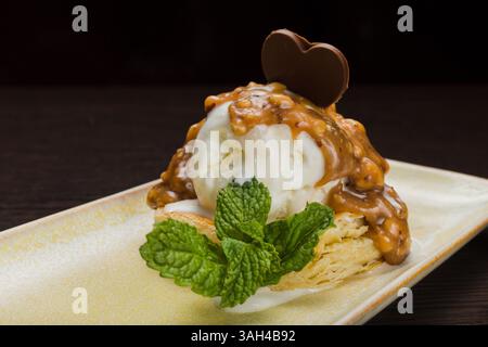 Dessert mit Blätterteig und Eis mit Karamell auf einem Teller Stockfoto