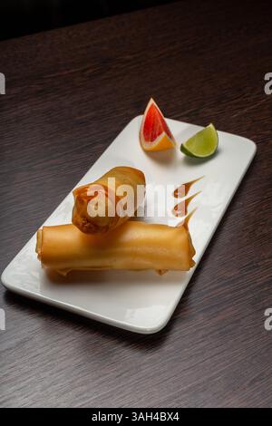 Japanische Pancakes auf einem weißen Teller mit Limette und Grapefruit Stockfoto