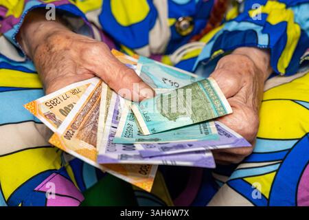 Indien Geld. Indische Seniorin, die indische Rupien in den Händen hält. Finanz- und Wirtschaftskonzept. Die finanzielle Situation der Senioren in Indien Stockfoto