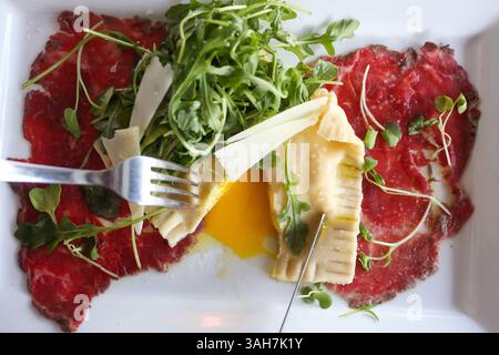 Mai 2015 - St. Petersburg, Florida, USA - EVE EDELHEIT | Times. Carpaccio aus Rinderfilet mit hausgemachten Ravioli .Filet Carpaccio, Haus-Ravioli gefüllt mit weichem pochiertem Ei, Lauch und Ziegenkäse Mousse, weißem Trüffelöl, geschliffenem Parmesan bei Brick & Mörtel in St. Petersburg am Donnerstag, 28. Mai 2015. (Bild: © Eve Edelheit/Tampa Bay Times/ZUMA Wire) Stockfoto