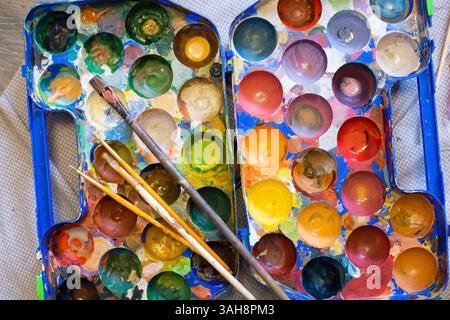 Draufsicht der Palette von Farben und Pinseln während der Arbeit Stockfoto