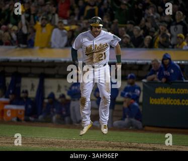 6. April 2015 - Oakland, Kalifornien, USA - Oakland Athletics Baserunner Stephen Vogt (21) springt nach dem vierten Lauf von Athletics auf einem wilden Feld von Texas Rangers auf, der Pitcher Yovani Gallardo (49) im vierten Inning am Montag, 6. April 2015, im MLB-Spiel zwischen den Oakland Athletics und Texas Rangers im O.Co Coliseum in Oakland, Kalifornien (Credit/VILRAMENA Wire) Stockfoto