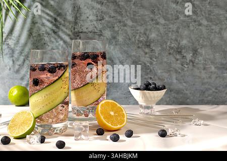 Erfrischendes Sommergetränk, kalte hausgemachte Limonade oder Cocktail mit Chiasamen, Heidelbeeren, Zitrone, Gurke und Limette auf einem sonnigen Tisch, Detox Diät Stockfoto