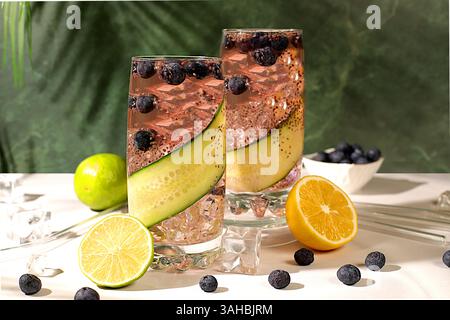 Kalte hausgemachte Limonade oder Cocktail mit Chiasamen, Heidelbeeren, Zitrone, Gurke und Limette auf einem sonnigen Tisch, Detox Diät und Sommerparty-Konzept. Ref Stockfoto