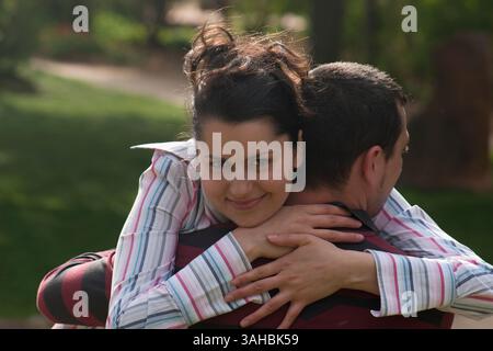 europäische Frau umarmt ihren Partner im Park Stockfoto