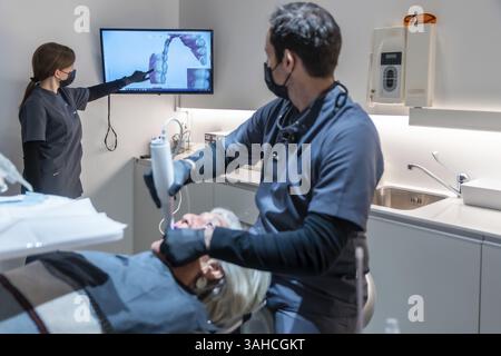 Zahnarzt und Assistentin mit Hilfe innovativer 3D-Scannertechnologie zur Verbesserung der zahnärztlichen Versorgung im modernen Klinikumfeld Stockfoto