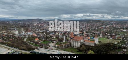 Luftpanorama von Hunedoara, restaurierte gotische Burg inmitten einer Industriestadt mit Bergwerk- und Fabrikschornsteinen in Rumänien Stockfoto