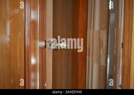 Nahansicht der Holzschranktür mit poliertem Metallknopf Stockfoto