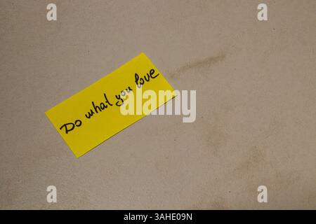Eine hellgelbe Haftnotiz liegt auf einer hellen Oberfläche und zeigt eine inspirierende Botschaft über die Verfolgung der eigenen Leidenschaften. Diese einfache Erinnerung erinnert an m Stockfoto