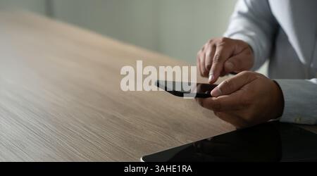 Mann hält die Hände und benutzt ein digitales Tablet Mobiltelefon mit leerem Kopierraum Stockfoto