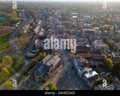 Brasschaat, Antwerpen, Belgien, 8. April 2025, eine atemberaubende Luftaufnahme, die während der bezaubernden goldenen Stunde eine ruhige Stadtlandschaft auf wunderschöne Weise festnimmt Stockfoto