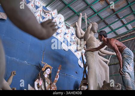 Die Künstlerin fertigt ein Tonidol der Göttin Durga in einer Werkstatt vor Durga Puja, einem großen Hindu-Festival, das in Indien und Bangladesch gefeiert wird. Stockfoto