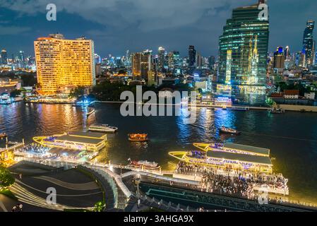 Bangkok, Thailand - 02. Juli: Nächtliche Szene des Flusslebens, beleuchtete Skyline der Stadt und Flussboote, Blick von der obersten Etage, Außenterrasse des Wahrzeichens Stockfoto
