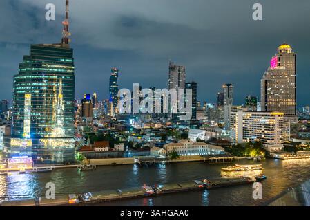 Bangkok, Thailand - 02. Juli: Nächtliche Szene des Flusslebens, beleuchtete Skyline der Stadt und Flussboote, Blick von der obersten Etage, Außenterrasse des Wahrzeichens Stockfoto