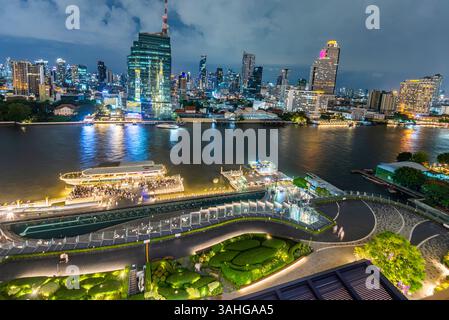 Bangkok, Thailand - 02. Juli: Nächtliche Szene des Flusslebens, beleuchtete Skyline der Stadt und Flussboote, Blick von der obersten Etage, Außenterrasse des Wahrzeichens Stockfoto