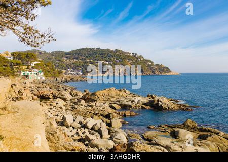Blick vom Küstenweg zwischen Llafranc und Calella, mit schroffen Klippen, Kiefern, Gebäuden und dem tiefblauen Mittelmeer, Costa Brav Stockfoto