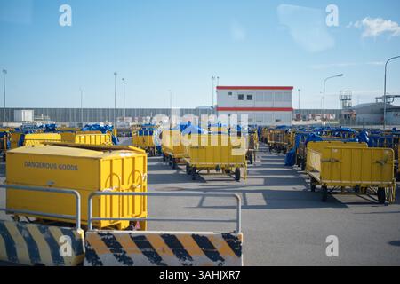 Gelbe Wagen mit der Kennzeichnung Gefahrgut in einem Industriegebiet mit Gebäude und blauem Himmel. Stockfoto