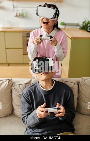 Ein glückliches Paar spielt zu Hause ein lustiges Virtual-Reality-Spiel und zeigt seine spielerische Energie. Stockfoto