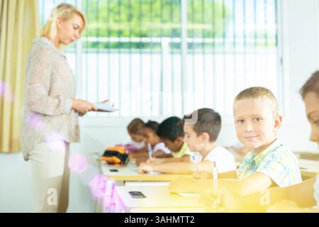 Ein Junge sitzt am Schreibtisch und lernt im Klassenzimmer Stockfoto