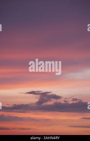 Leuchtende Farben bei Sonnenuntergang erfüllen den Himmel über dem Meer Stockfoto