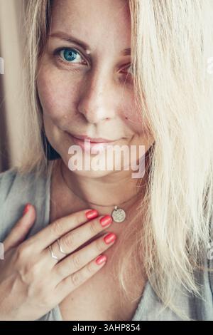 Schöne Frau mittleren Alters zeigt rote Schellack Maniküre auf Nägeln. Stockfoto