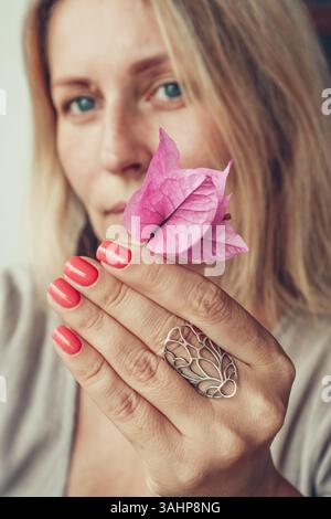 Schöne Frau mittleren Alters zeigt rote Schellack Maniküre auf Nägeln. Stockfoto